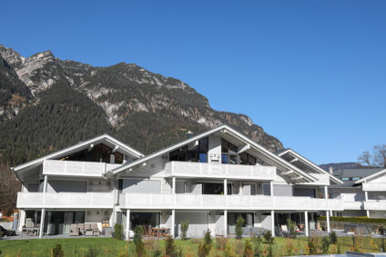 Ansicht des Wohnhaus-Ensembles mit Bergpanorama im Hintergrund.